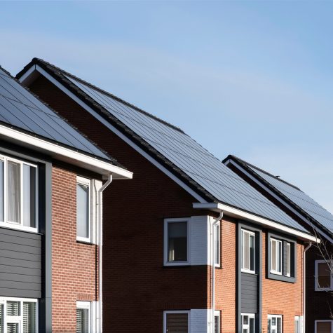 Solar Panels mounted on the tile roofs o a row of modern residential properties