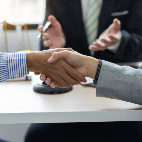 Two business people shaking hands after a mediator has helped resolve a dispute